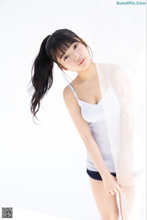 A woman in a black one piece swimsuit posing for a picture.