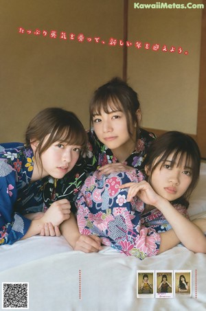 A group of women in kimonos laying on top of a bed.