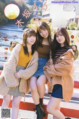 A group of three young women laying on top of a bed.