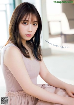 A woman in a black and white striped dress posing for a magazine.