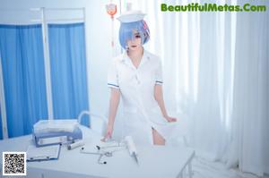A woman in a nurse outfit is posing on a bed.
