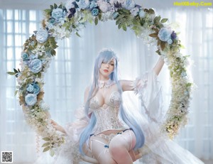 A woman with blue hair sitting on a white chair.