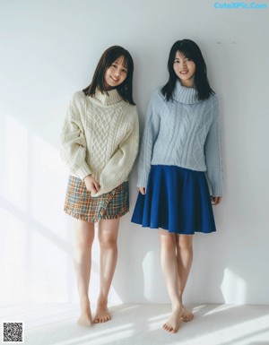 A couple of young women standing next to each other on a street.