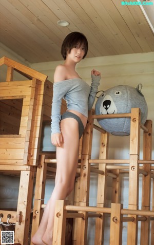 A woman in a blue bra top is posing for a picture.