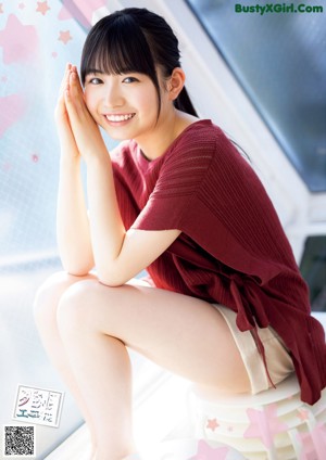 A woman with long black hair is posing for a magazine.
