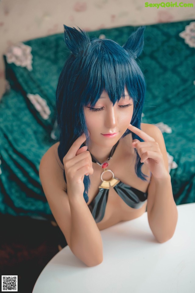 A woman with blue hair sitting at a table.