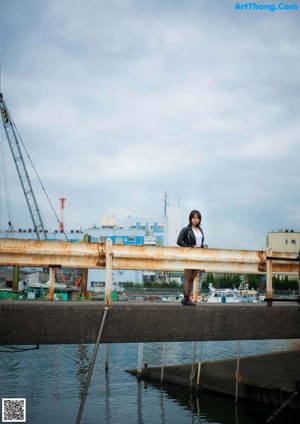 A woman leaning against a wall with her arms crossed.