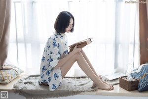 A woman in a blue lingerie sitting on a bed.