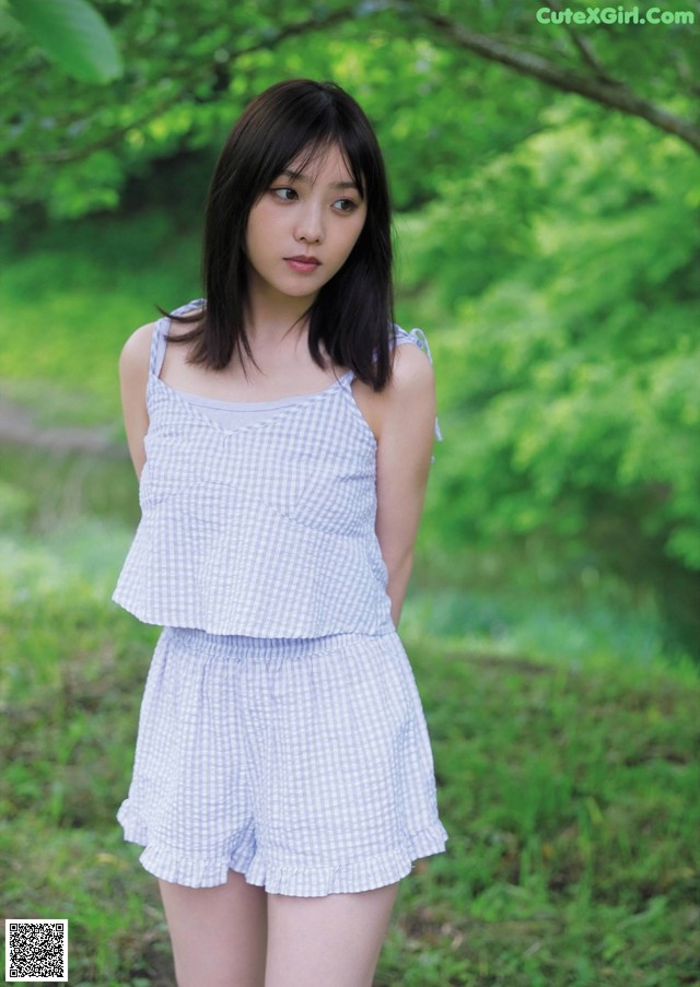 A woman in a blue and white striped top and shorts.