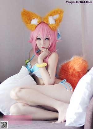 A woman in a fox costume sitting on a couch.