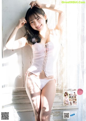 A woman in a white lingerie sitting on a chair.