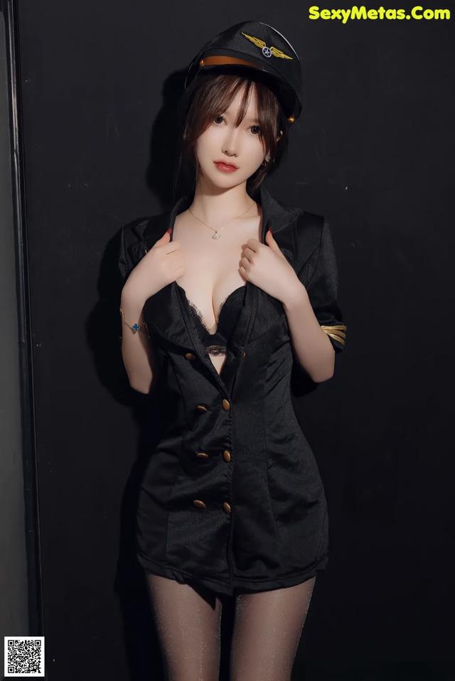 A woman in a black uniform posing for a picture.