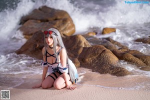 A woman in a blue and white outfit is standing in the water.