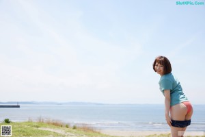 A woman in pajamas peeking out from behind a wall.