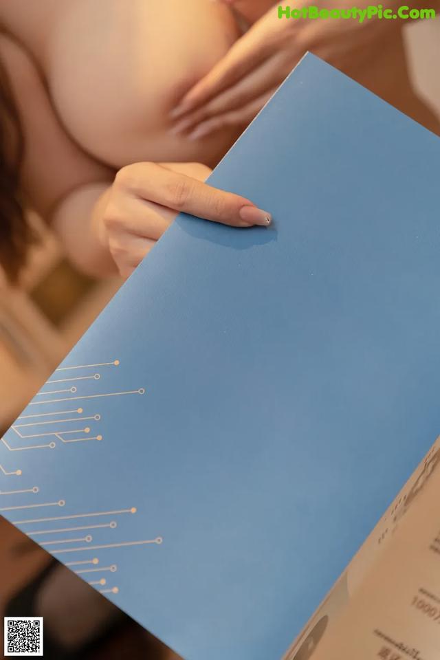 A woman holding a blue folder with a circuit board on it.