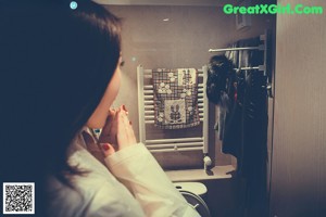 A woman in a white raincoat standing in a room.