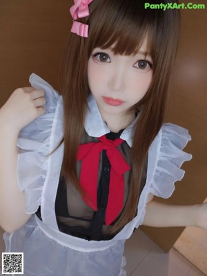 A woman in a maid outfit posing for the camera.
