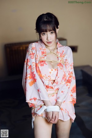 A woman in a kimono sitting on the edge of a pool.