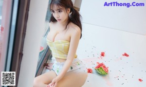 A woman sitting on a bed eating a slice of watermelon.