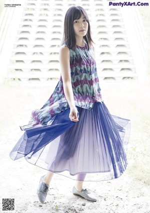 A woman with long black hair wearing a colorful dress.