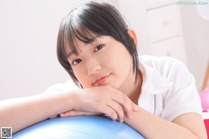 A woman sitting on top of a blue ball.