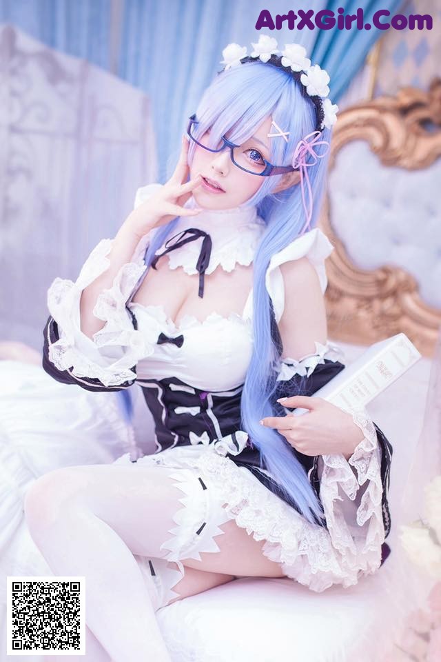 A woman in a maid outfit sitting on a bed.