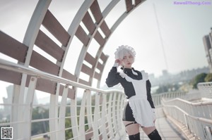 A woman in a maid outfit holding a gun.
