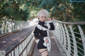 A woman in a maid outfit holding a gun.