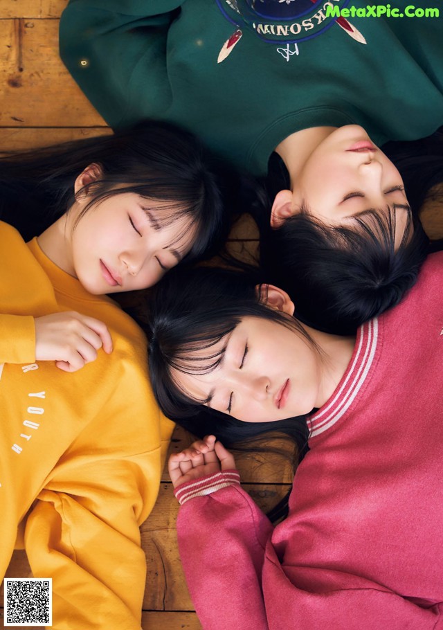 A group of young women laying on top of a wooden floor.